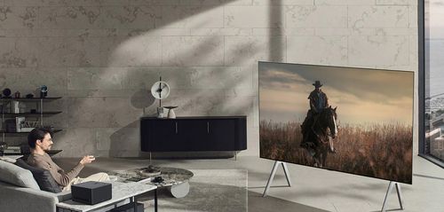  A person watching the LG M3 OLED Smart TV.