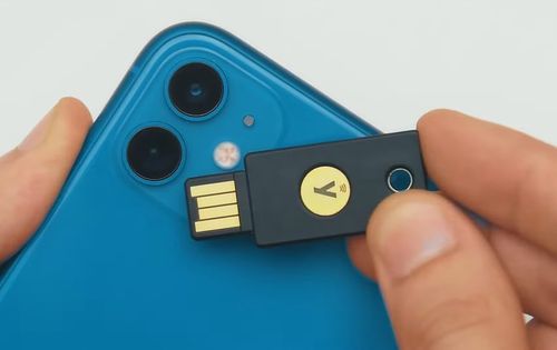 A Yubico physical security key atop an iPhone 11.